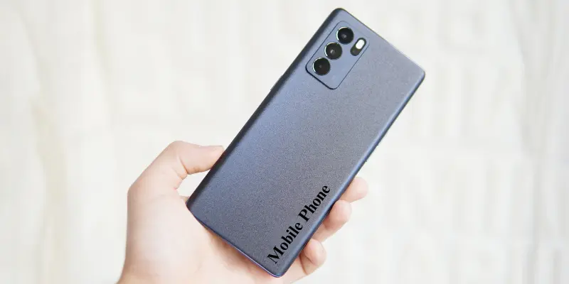 Close-up of a modern mobile phone with the text 'Mobile Phone' printed on its back, showcasing the sleek design and camera features.